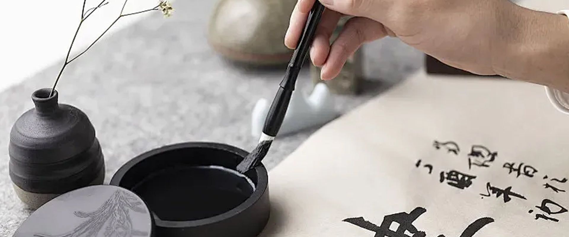 The banner image of the website - a calligraphy enthusiast is practicing calligraphy.